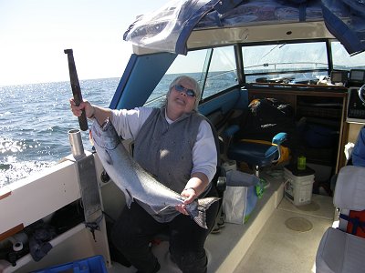 Guest from Alberta  on a beautiful April day shows off her salmon she caught on the surf line just out from Barkley Sound