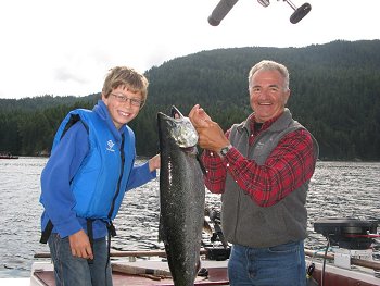 Guest Eric and mom Shelley (not shown) is excited about his Chinook Salmon caught in the Alberni Inlet.  Guide Mel of Slivers Charters Salmon Sport Fishing is shown in the picture with Eric and the salmon which was caught in Bells Bay, Port Alberni Inlet on an anchovy.