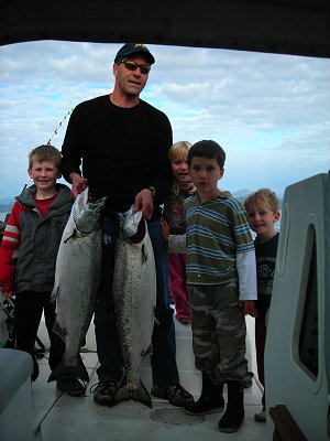 Pictured is guide John showing a 24 and 25 pound Chinook caught at Swale Rock.  With John are Malika, Isaac, Matthew and Zack.  Isaac and Mat each had opportunity to catch one of these big Chinook.  The Chinook were caught close to Swale Rock in Barkley Sound