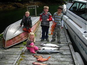 This picture is of four kids who enjoyed a trip with guide John.  With the kids was dad Ray not seen.  Young kids can enjoy some of the early fishing in Barkley Sound.  In picture are three Chinook and some rock fish.