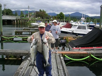 Mike of Timmins Ontario shows off two salmon he picked up in Barkley Sound.  Picture is taken on Clutesi Haven Marina in Port Alberni.  Mikes' Guide was Doug of Slivers Charters Salmon Sport Fishing